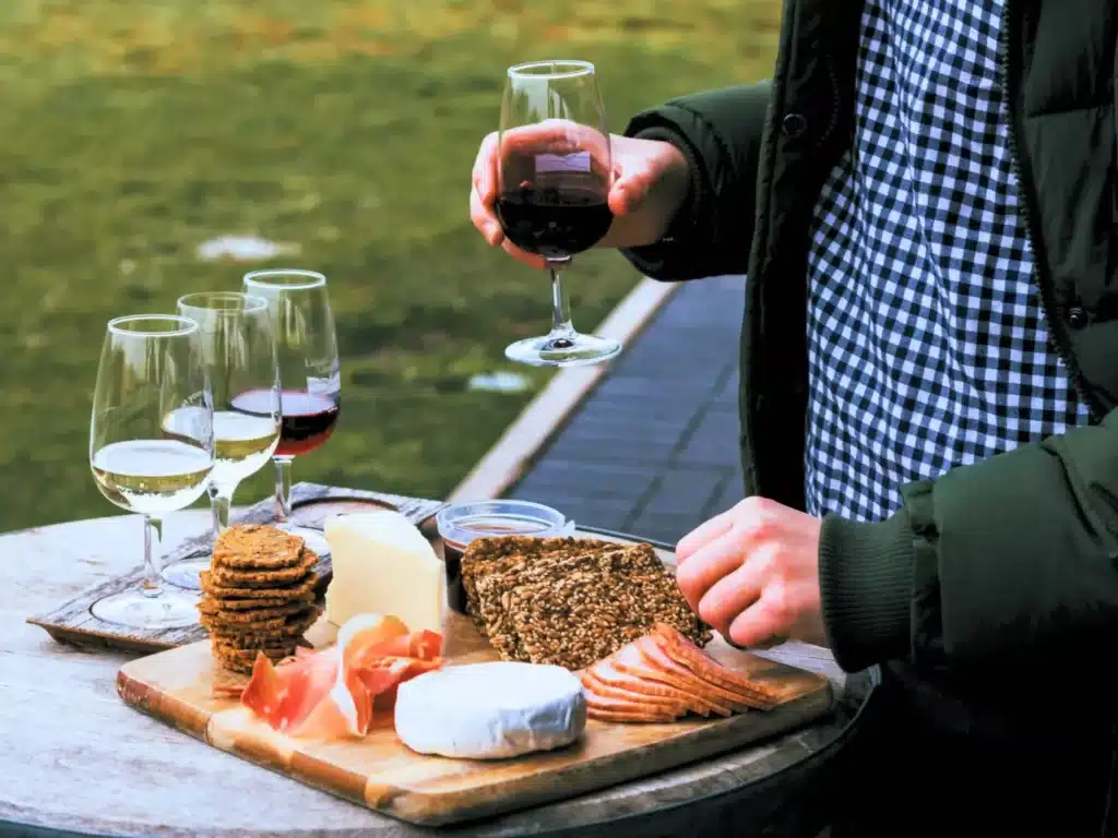 homme avec fromages et verres de vin scaled