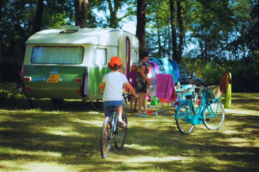 kind fietst in de buurt van een camper