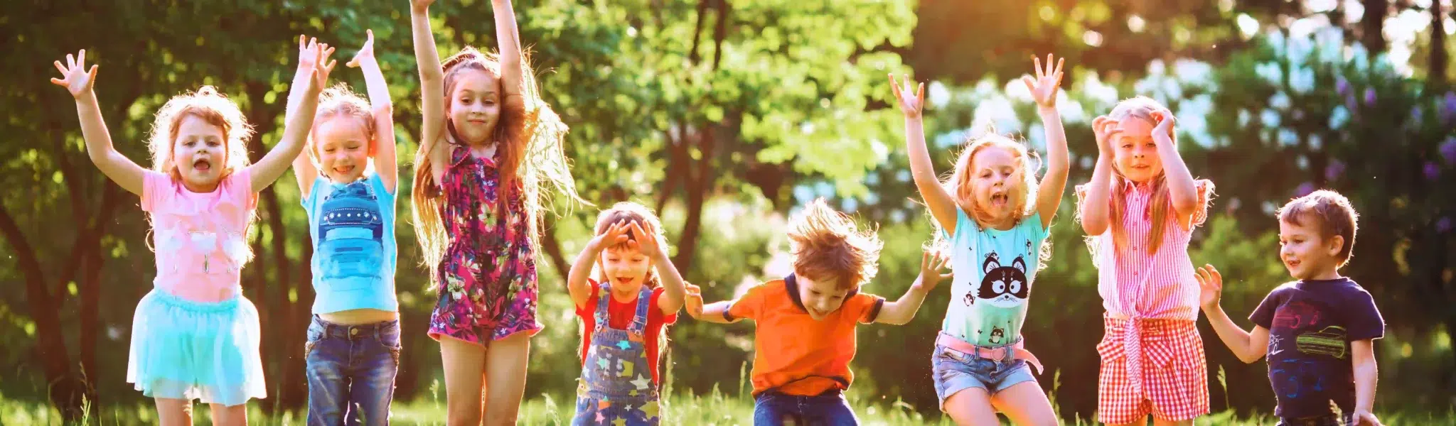 enfants qui sautent dans l'herbe